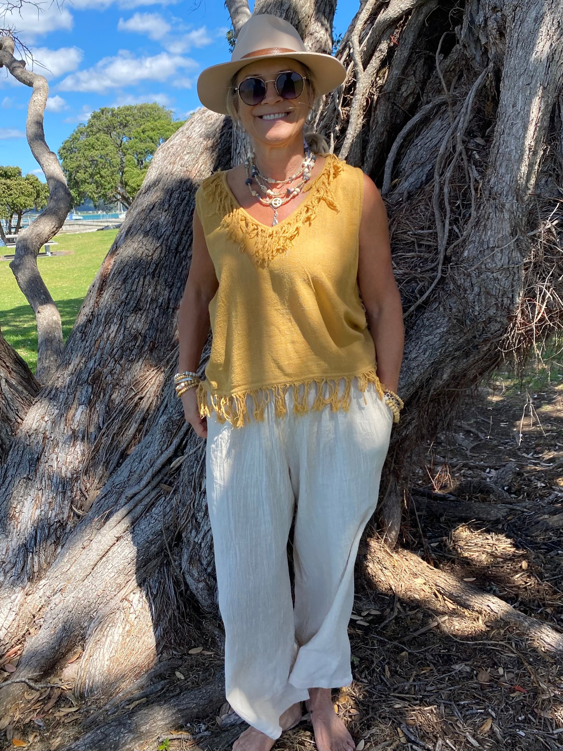 Sukaah natural ramie top with soft fringe detail designed for relaxed resort styling.